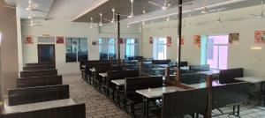 a dining room with black chairs and tables at Hotel Shree Ram in Kishangarh