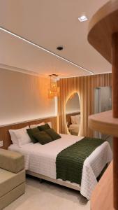 a bedroom with a large bed and a mirror at Novíssimo Flat Beach Class Solare - Muro Alto -Soft Open in Porto De Galinhas +35 photos
