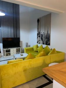 a living room with a yellow couch and a television at Saada in Tangier