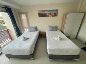 two beds in a room with swans on them at M&M Kata Beach in Kata Beach