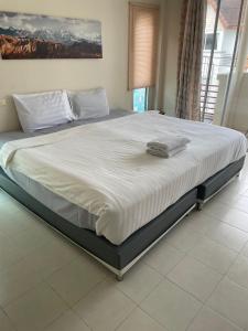 a large bed with white sheets and pillows on it at M&M Kata Beach in Kata Beach +5 photos