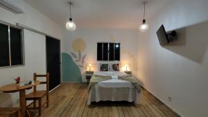 a bedroom with a bed and a table and lights at Pousada Flor do Campo in Serra do Cipo +69 photos