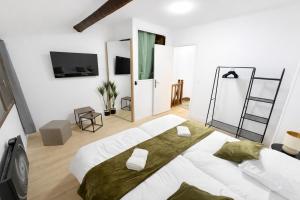 a white bedroom with a large bed in a room at Maison Connectée Serenia in Méru +3 photos