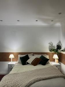 a bedroom with a large bed with two lamps at The Wavers Ideal for airport links NEC JLR in Marston Green