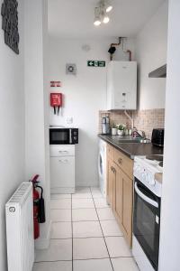 a white kitchen with a sink and a dishwasher at The Wavers Ideal for airport links NEC JLR in Marston Green