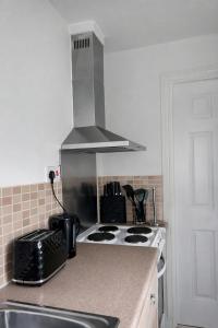 a kitchen with a stove and a counter top at The Wavers Ideal for airport links NEC JLR in Marston Green