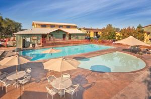 a large swimming pool with tables and chairs and umbrellas at WorldMark Angels Camp in Angels Camp