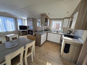 a kitchen and living room with a table and a dining room at Poole Rockley Park Dorset in Poole