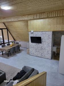 a living room with a stone fireplace with a tv at Shabran Pearl A-Frame in Surra