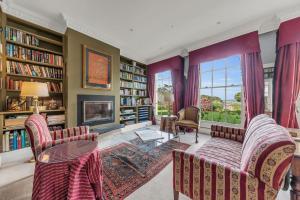 a living room with two chairs and a fireplace at Castle by the Sea - Tilba Road 26 in Bermagui