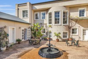 a courtyard with a fountain in front of a building at Castle by the Sea - Tilba Road 26 in Bermagui
