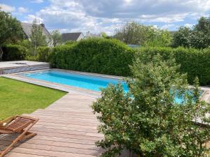 a swimming pool in a yard with a wooden deck at Ty Moune in Crach