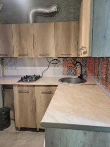 a kitchen with wooden cabinets and a sink at Elan apartment in Gori