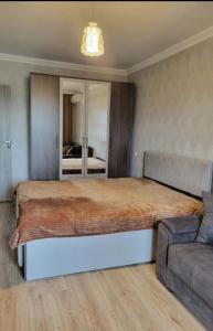 a bedroom with a large bed and a couch at Elan apartment in Gori