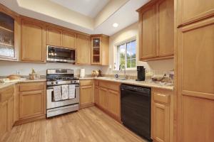 a kitchen with wooden cabinets and a black dishwasher at Healdsburg Wine Country Escape with Tasting Perks & Vineyard Views in Healdsburg