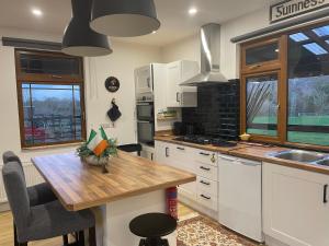 a kitchen with white cabinets and a wooden table at Cosy nap under the Paps in Killarney