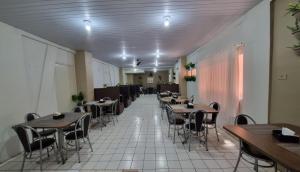 a restaurant with tables and chairs in a room at Ambassador Hotel in Foz do Iguaçu