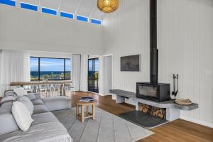 a living room with a couch and a fireplace at Fishers - Scenic Drive 35 in Bermagui