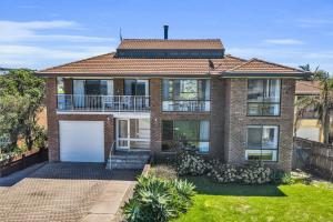 a brick house with a white garage at Fishers - Scenic Drive 35 in Bermagui