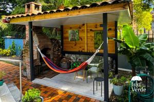 a hammock on a patio with a fireplace at Hotel Isla Verde in Boquete +26 photos