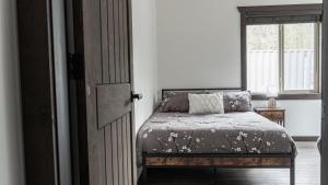 a bedroom with a bed and a window at Polar Den Cabin in Valemount