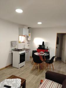 a kitchen and living room with a stove and a table at Cabañas Haru Puerto Natales in Puerto Natales