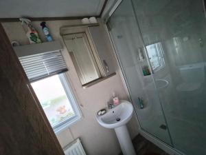 a small bathroom with a sink and a shower at Hills residence in Morecambe +1 photo