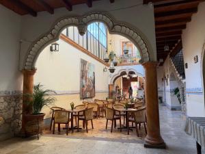 a restaurant with tables and chairs in a building at Hotel Centenario Bernal in Bernal