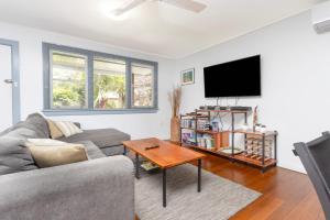 a living room with a couch and a tv at Koala Lodge Cottage 5 in Iluka