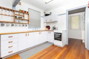 a kitchen with white cabinets and a stove at Koala Lodge Cottage 5 in Iluka