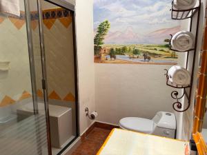 a bathroom with a toilet and a painting on the wall at Hotel Centenario Bernal in Bernal +41 photos