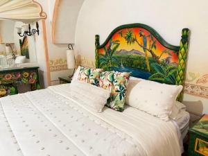 a bedroom with a large bed with a painting on the wall at Hotel Centenario Bernal in Bernal