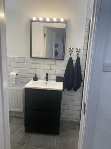 a bathroom with a black sink and a mirror at Cosy nap under the Paps in Killarney +34 photos