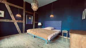 a blue bedroom with a bed with a blue wall at Der Pfeil - Gutshaus Bückling in Rambin