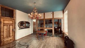 a dining room with a chandelier and a table at Der Pfeil - Gutshaus Bückling in Rambin