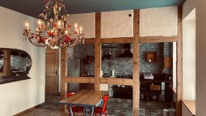 a dining room with a wooden table and a chandelier at Der Pfeil - Gutshaus Bückling in Rambin