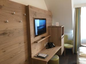 una habitación con TV en una habitación de hotel en Villa Benz Hotel garni, en Schwetzingen