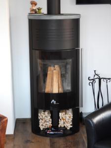 a black fireplace with logs inside of it at Chalet panoramique avec vue alpine à 180 degrés - poêle scandinave & nature in Grône +8 photos