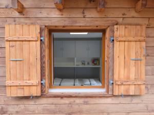 a window in a wooden building with a room at Chalet panoramique avec vue alpine à 180 degrés - poêle scandinave & nature in Grône