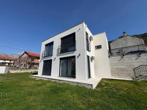 a large white house with a grass yard at Villa Maja in Trebinje