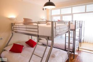 two bunk beds in a small room with red pillows at Help Yourself Hostels - Carcavelos Coast in Carcavelos +46 photos