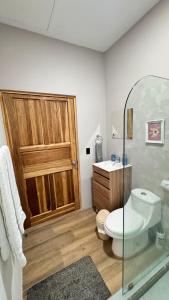 ein Badezimmer mit Holztür, Toilette und Waschbecken in der Unterkunft GZ Studios in Coco + 12 Fotos