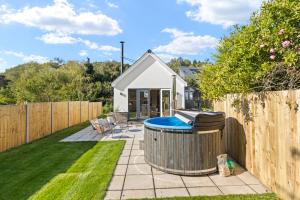 a backyard with a hot tub and a fence at Vine Cottage in Westfield