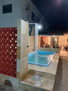 a swimming pool at night with a water fountain at Espaço Nossa Casa, Piscina e churrasqueira Privativas in Paulista