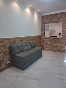 a couch in a room with a brick wall at Espaço Nossa Casa, Piscina e churrasqueira Privativas in Paulista