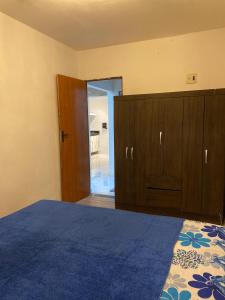 an empty bedroom with a bed and wooden cabinets at Espaço Nossa Casa, Piscina e churrasqueira Privativas in Paulista