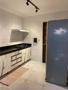 a kitchen with a blue refrigerator in a room at Espaço Nossa Casa, Piscina e churrasqueira Privativas in Paulista