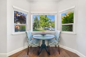 a dining room with two chairs and a table and two windows at Condo with Sauna & Fitness Center, Adjustable Base King Sized Bed in Coeur d'Alene