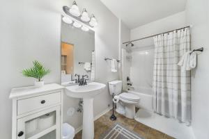 a white bathroom with a sink and a toilet at Condo with Sauna & Fitness Center, Adjustable Base King Sized Bed in Coeur d'Alene
