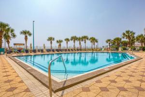 a swimming pool at a resort with palm trees at Oceanfront Condo #507 at Summit Beach Resort in Panama City Beach
